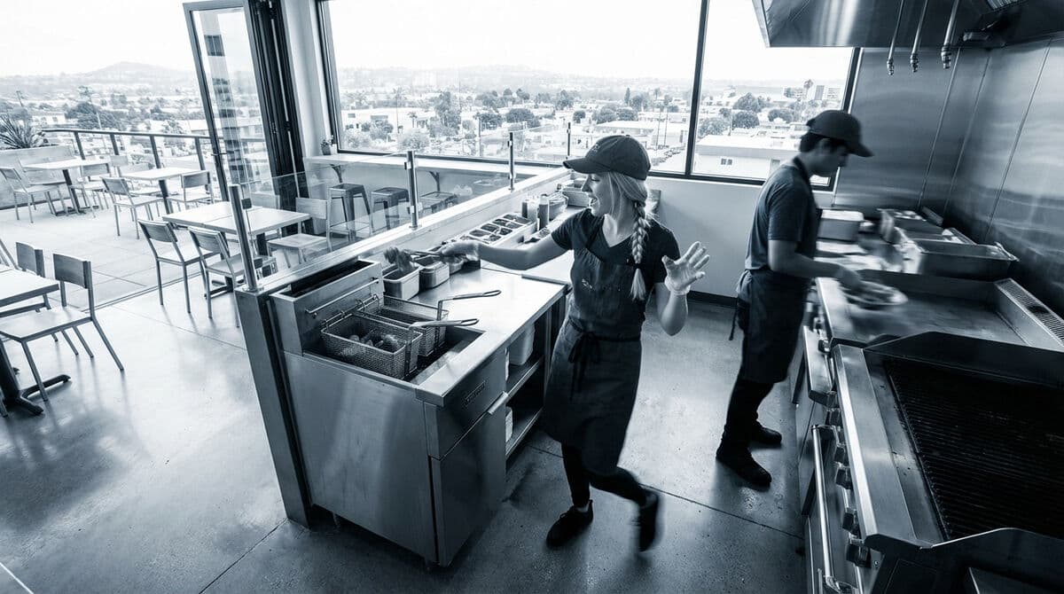 Overhead view of franchise kitchen team coordinating operations during service