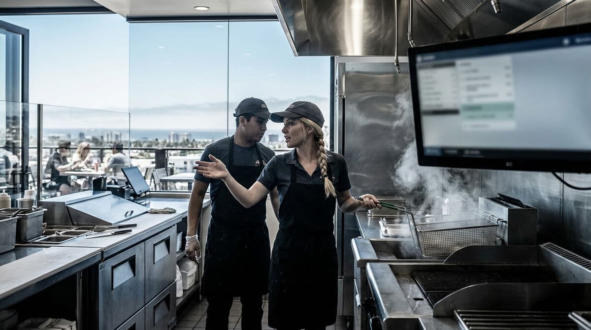 Franchise kitchen staff reviewing operational data on screen together
